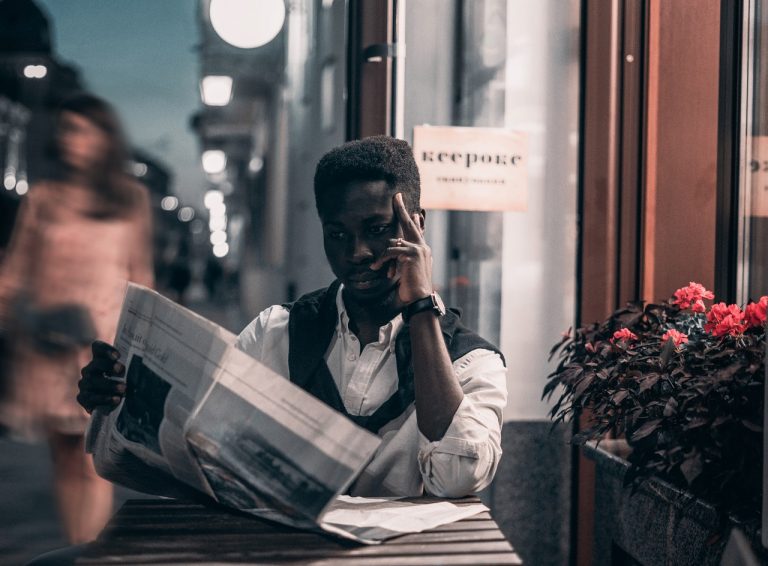 man reading newspaper cafe image